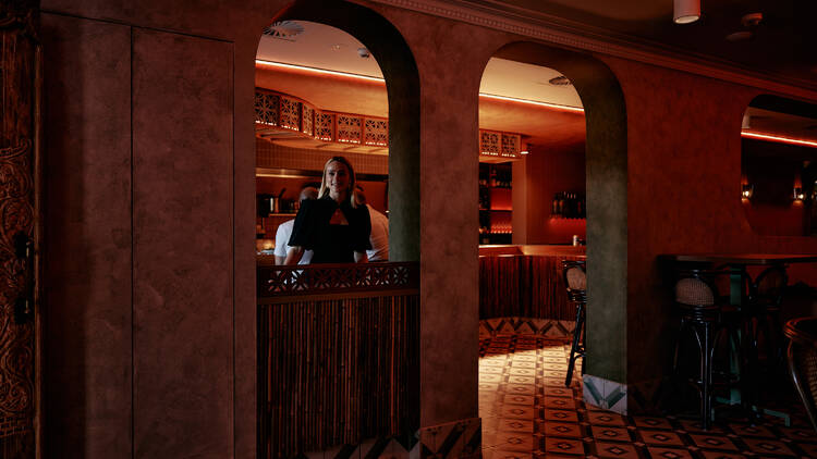 Woman standing under the arched walls at Casa Chino.