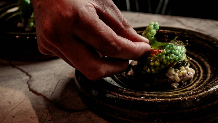 Chef preparing a dish at Babae.