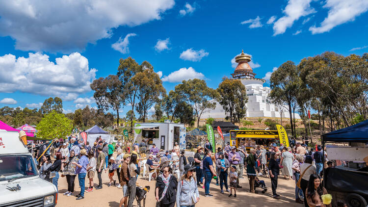 People walking around outside the Great Stupa of Universal Compassion.