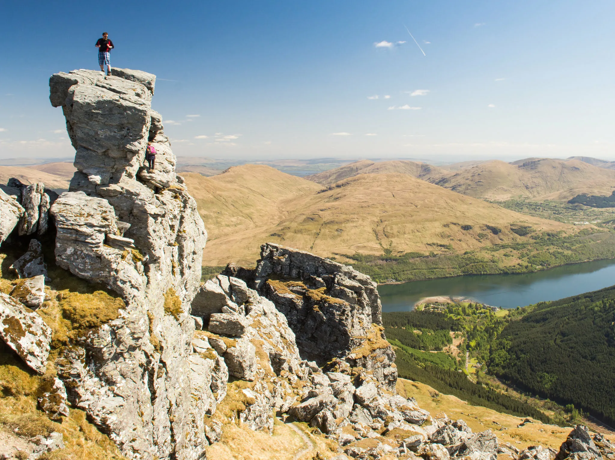 A hiker reaches the summit of Beinn Artair, "The Cobbler", a popular mountain for walking in the Arrochar Alps range of the West Highlands of Scotland.