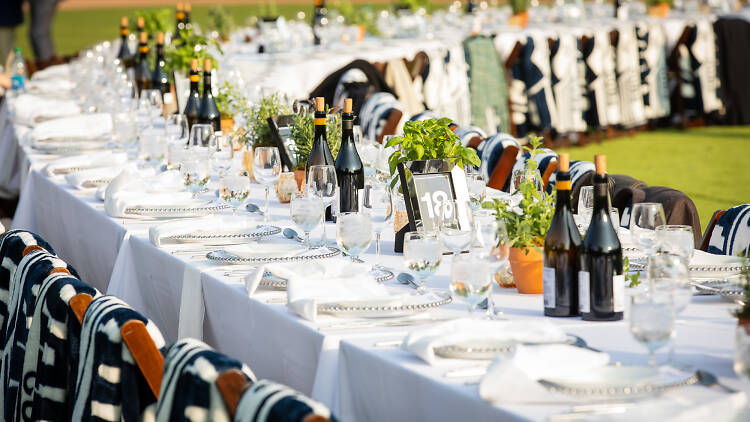 A curved table with a white tablecloth and wine glasses