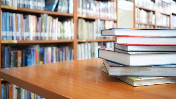 Stock photo of a school library, with books on a table