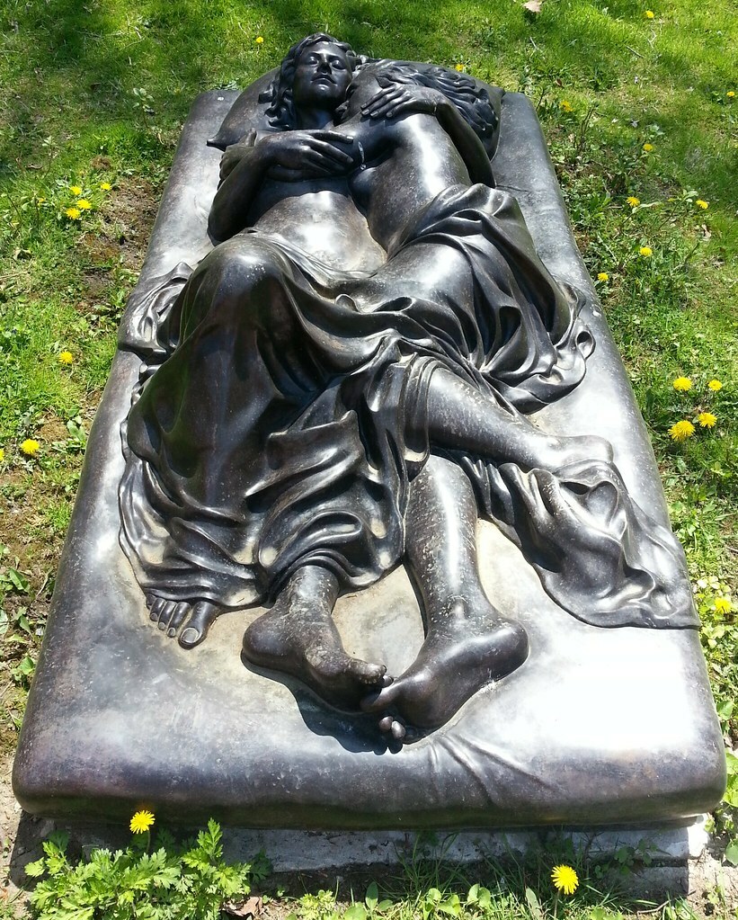 A sculpture of two women intertwined on a bed.