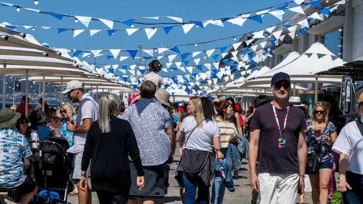 People walking at outdoor festival in sunshine