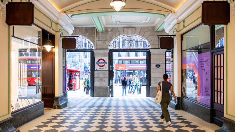 A woman walks past shopfronts of the restored Victoria Arcade in central London.