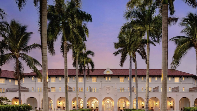 Palace like facade of Casa Marina hotel line by palm trees.