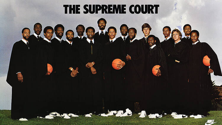 A group of basketball players dresses in judge robes.