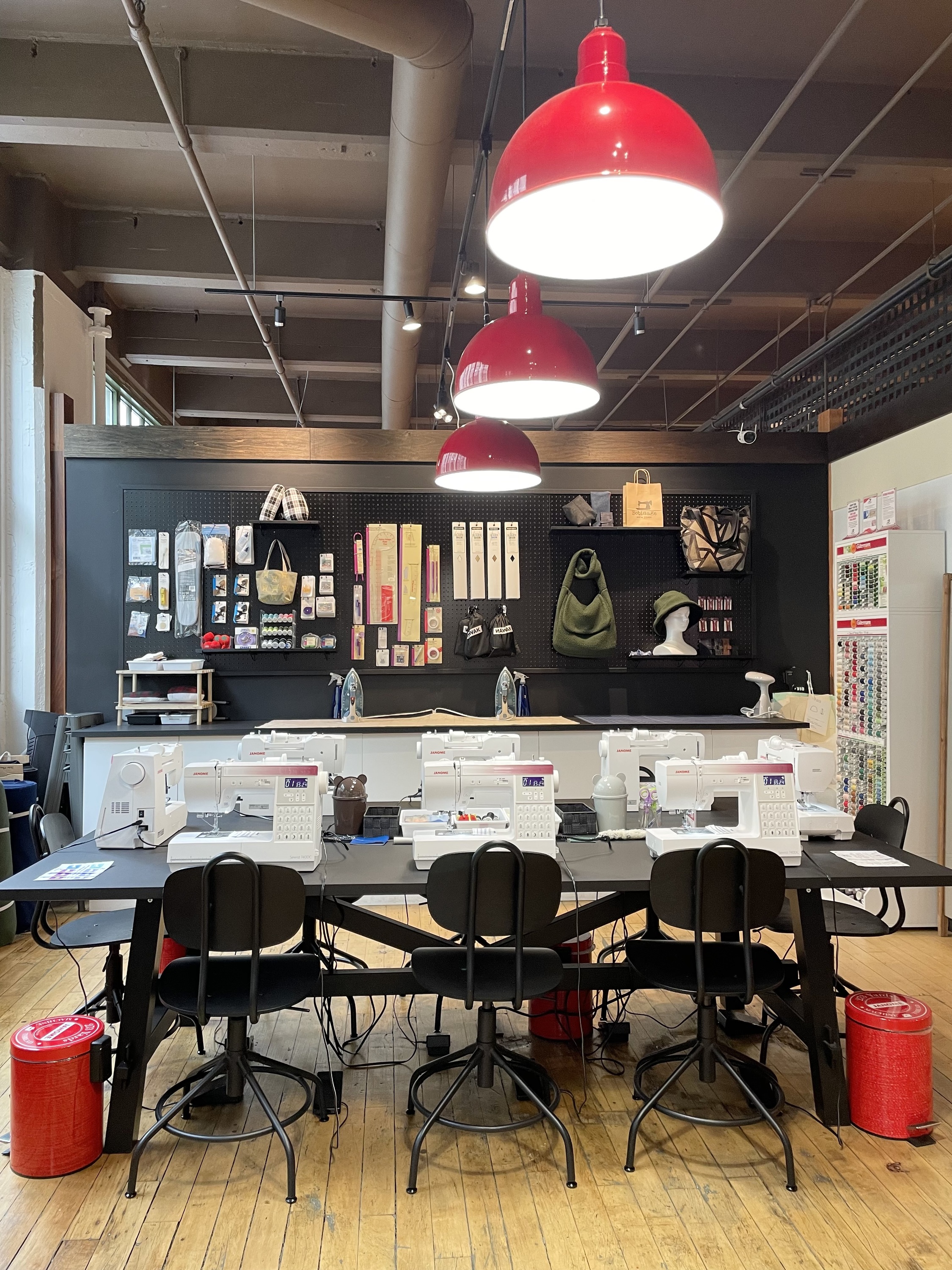 Sewing room at Bobinage with eight white sewing machines