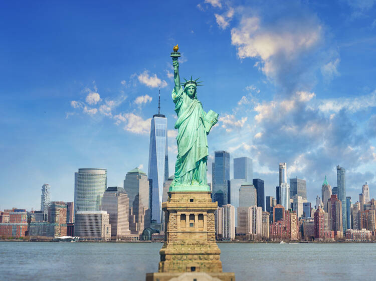 Statue of Liberty with skyline behind 