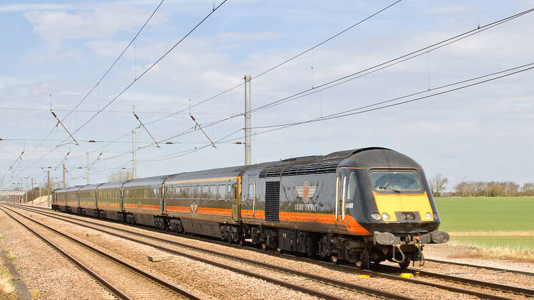 A Grand Central rail company branded train on a track in the sun in northern England.