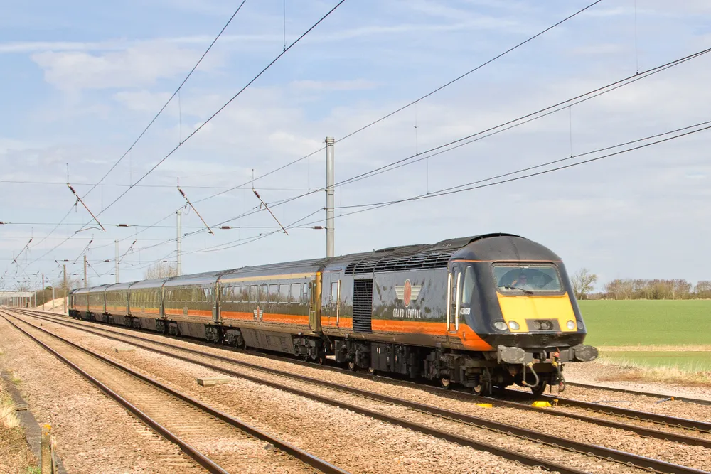 A Grand Central rail company branded train on a track in the sun in northern England.