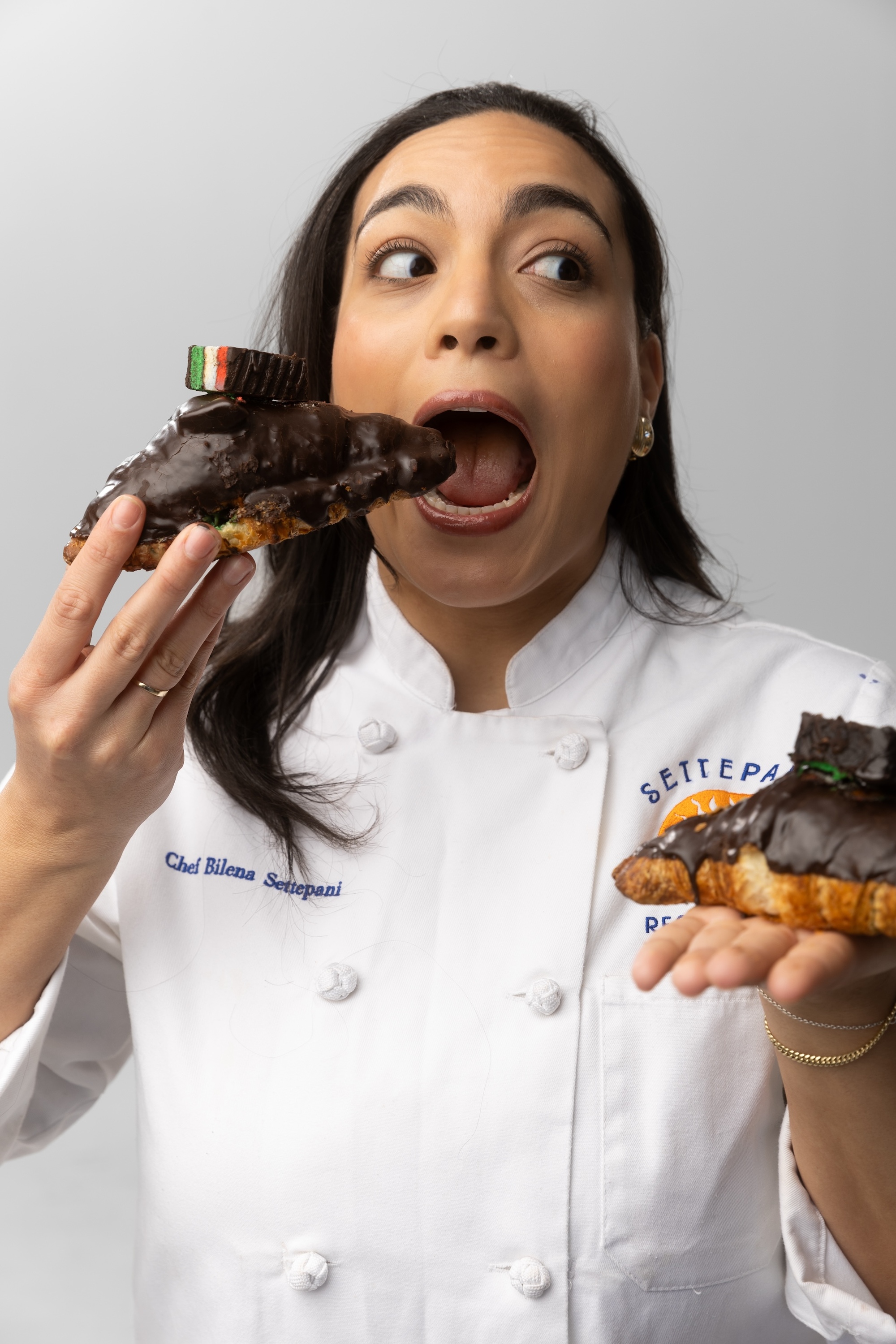 Bilena Settepani holding two of her rainbow cookie croissants