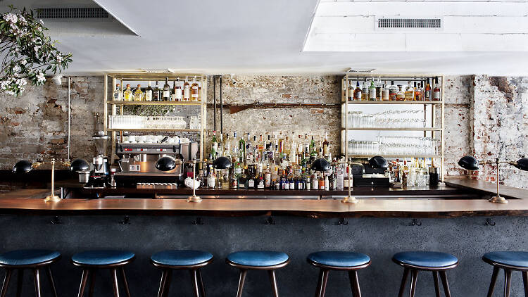 Wooden bar with blue seats at Musket Room