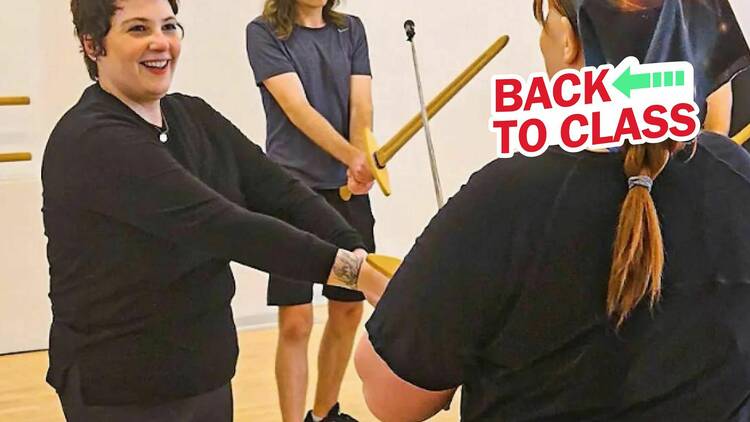 A woman takes a sword fighting class.