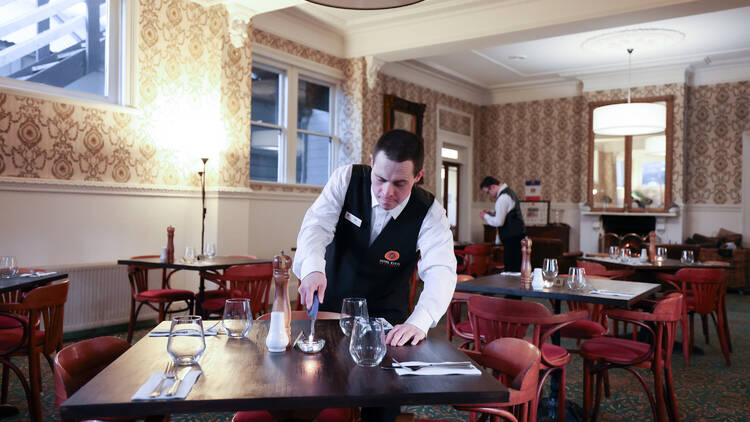 Staff setting up the dining room for guests at Hotel Etico, Mount Victoria