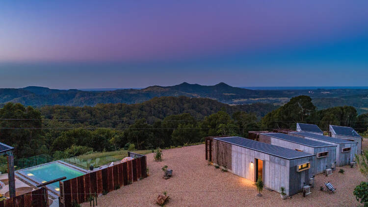 View of property with pool at sunset