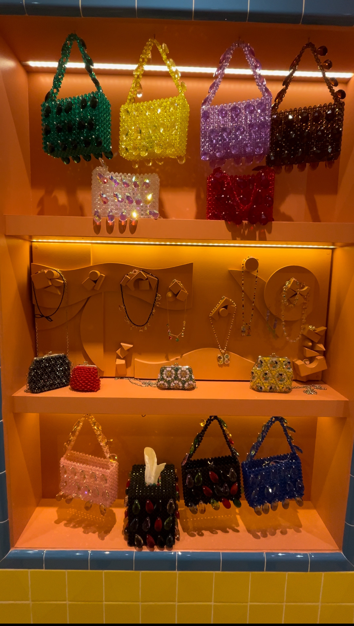 A wall of beaded handbags