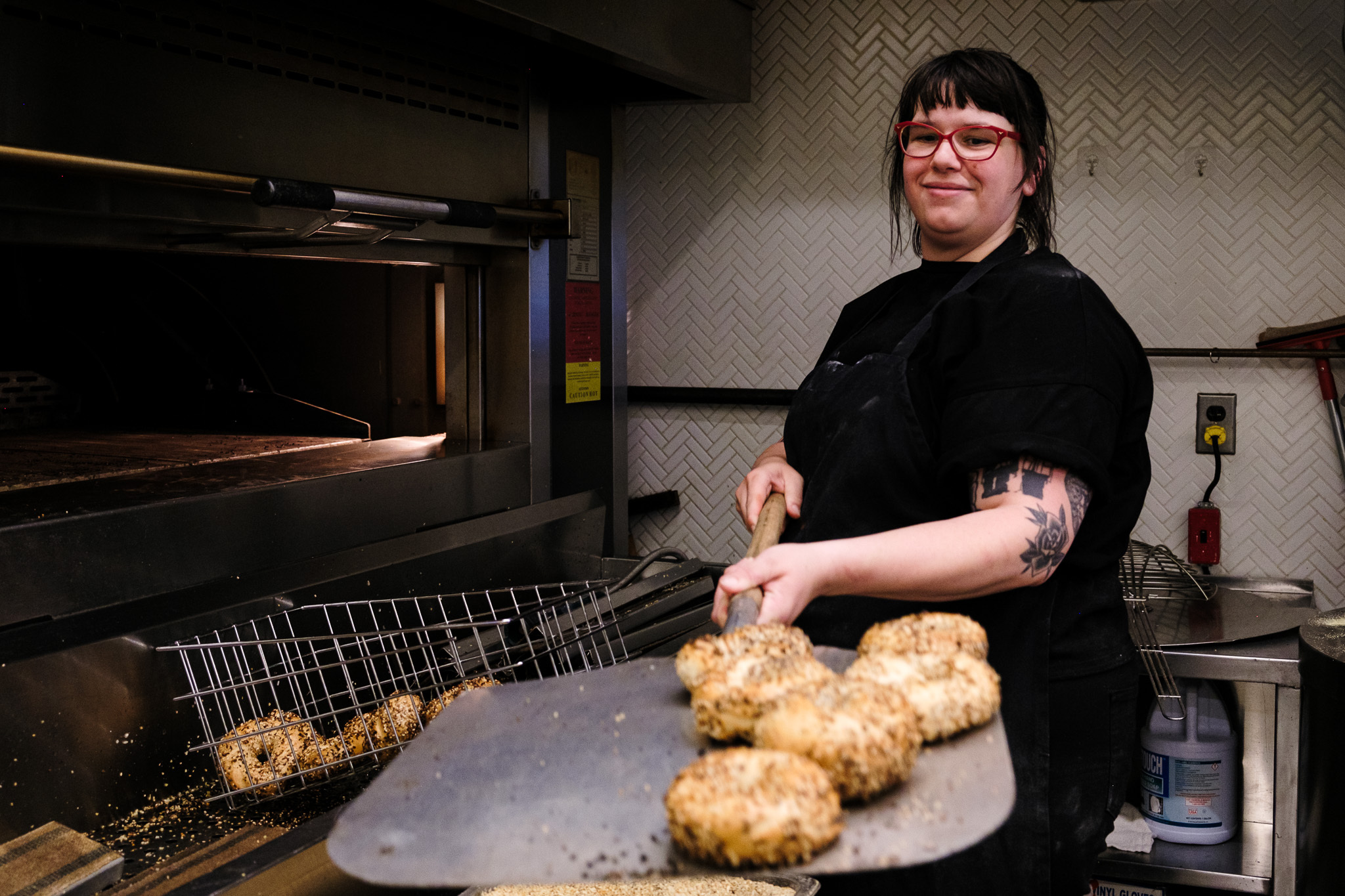 Reva Castillenti holding a metal spatula with bagels