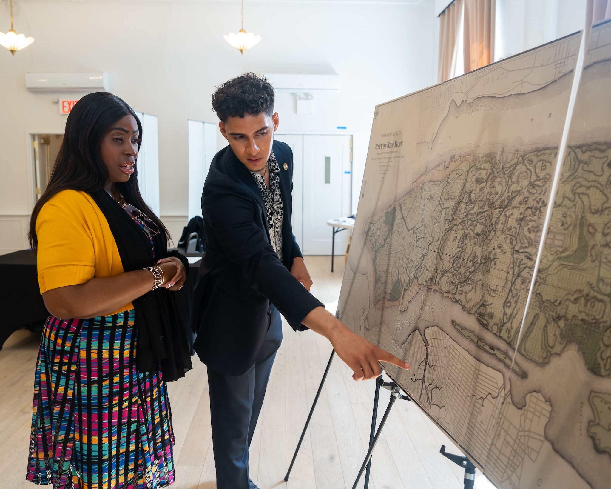 Two people look at a large map.