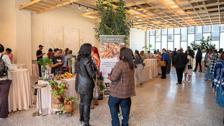 A white room filled with people standing for a culinary conference