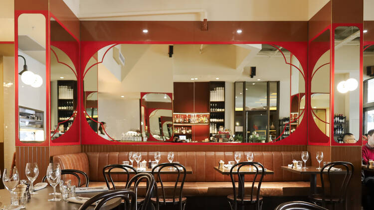 Elegant CBD brasserie's red and leather interiors.