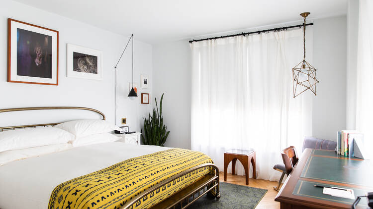 A guest room with a white bed.