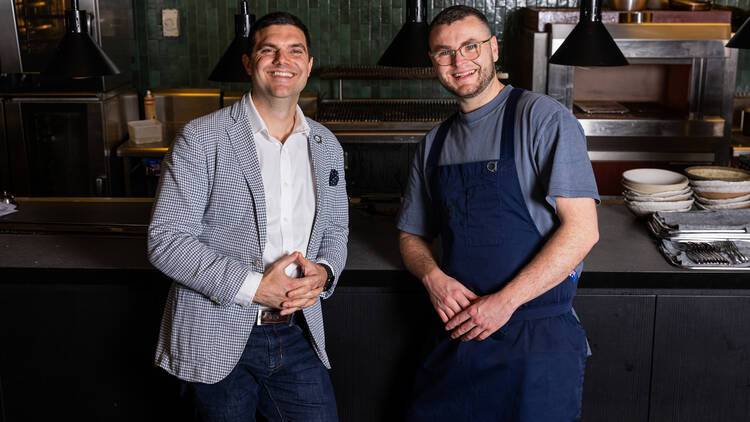 Two men standing at a bar