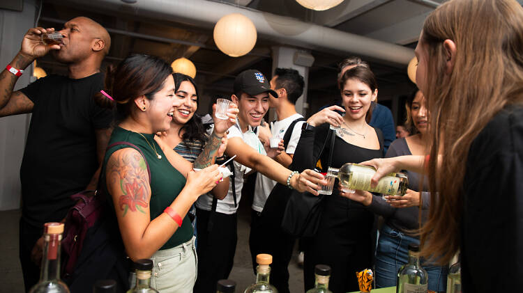 A group of people holding shots of tequila