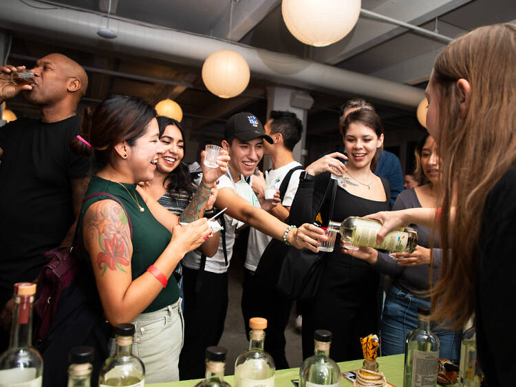 A group of people holding shots of tequila