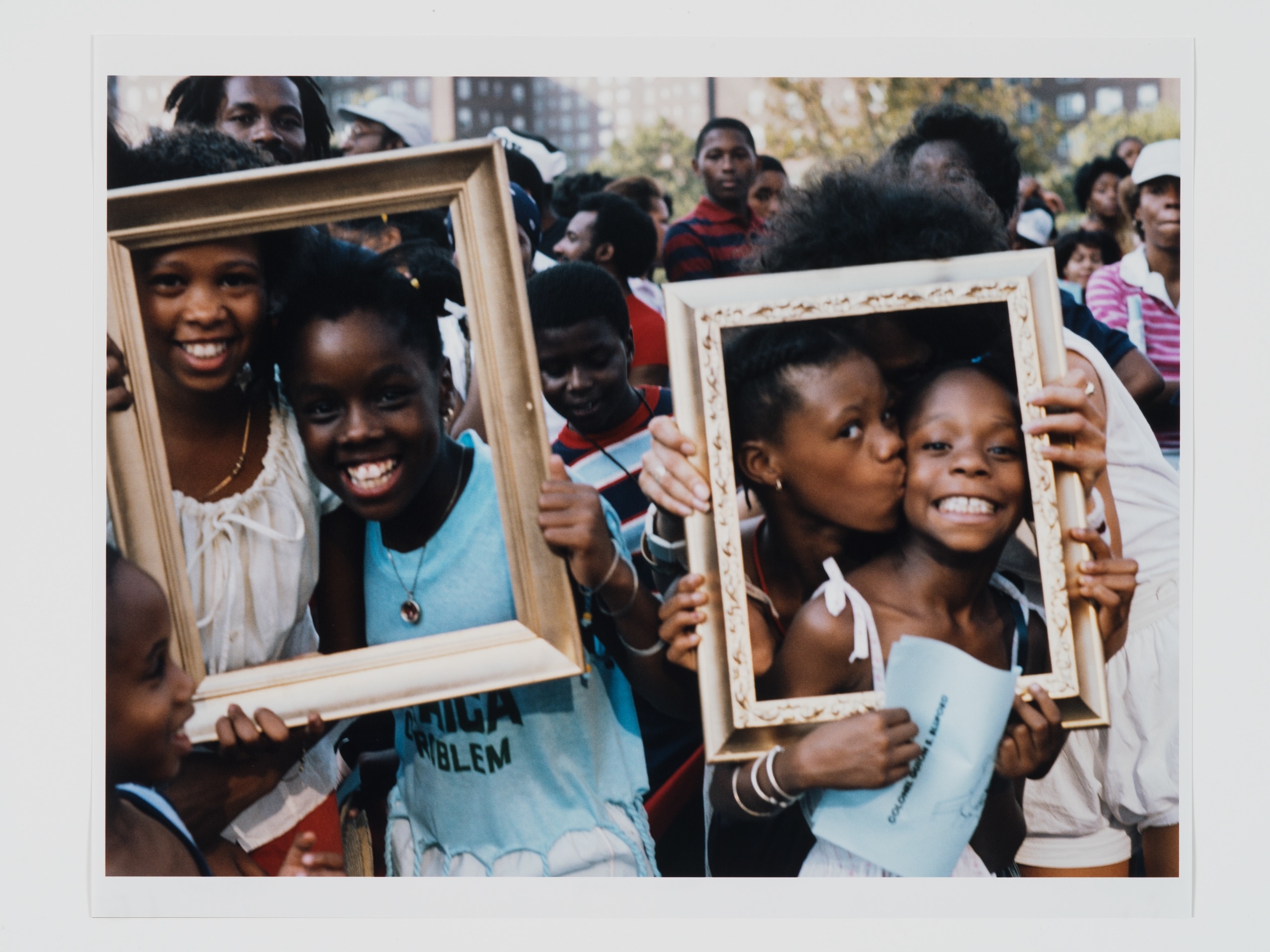 A group of kids holds up photo frames for a picture.