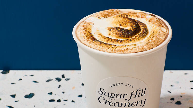 Hot chocolate with a toasted marshmallow topping and chocolate shavings next to it