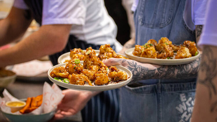 People in aprons holding plates of food.