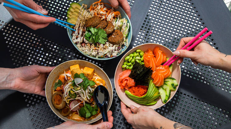 Three bowls of food on a table.