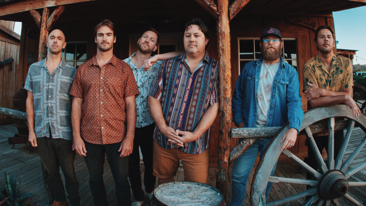 The six members of Iration pose in a ghost town.