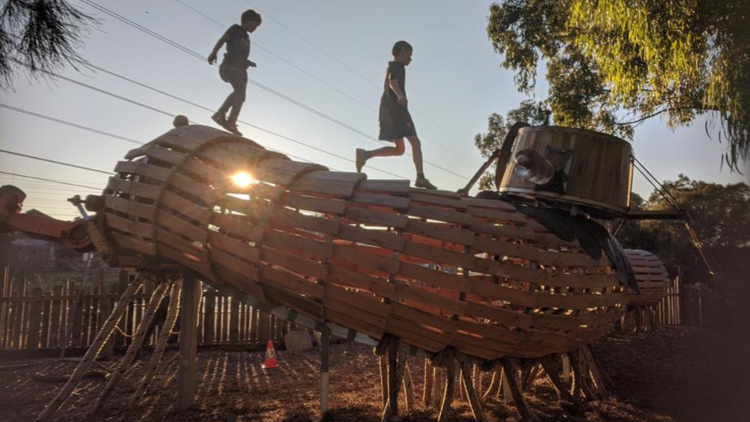 Children playing on a wooden playground. 