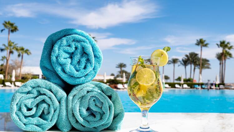 hotel pool with towels and cocktail