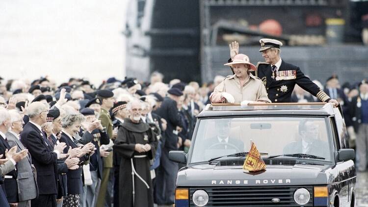 The Queen of England rides in a Range Rover SUV.