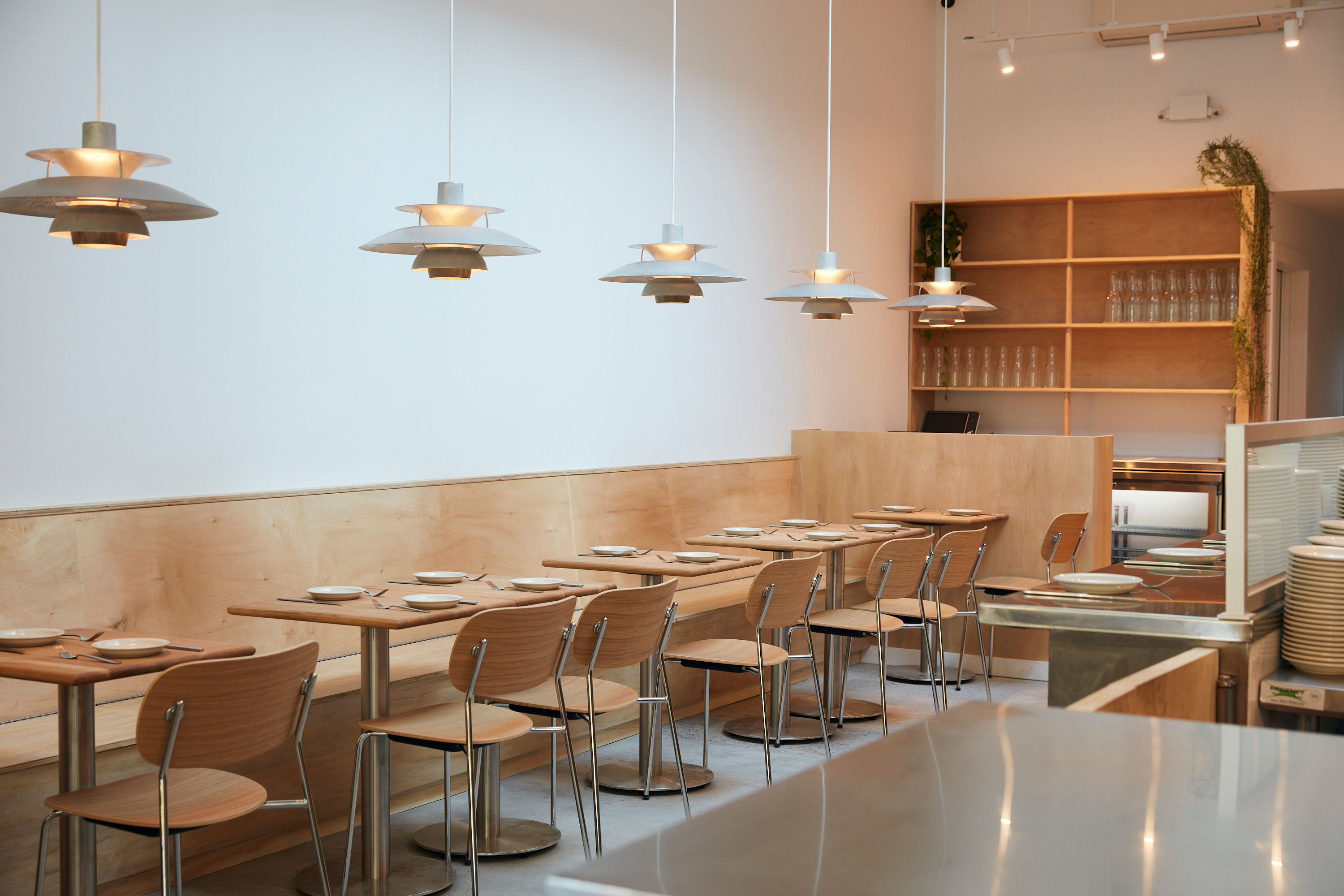 White blond booths, tables and chairs against a white wall