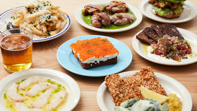 a table full of crudo, open faced sandwiches and toasts