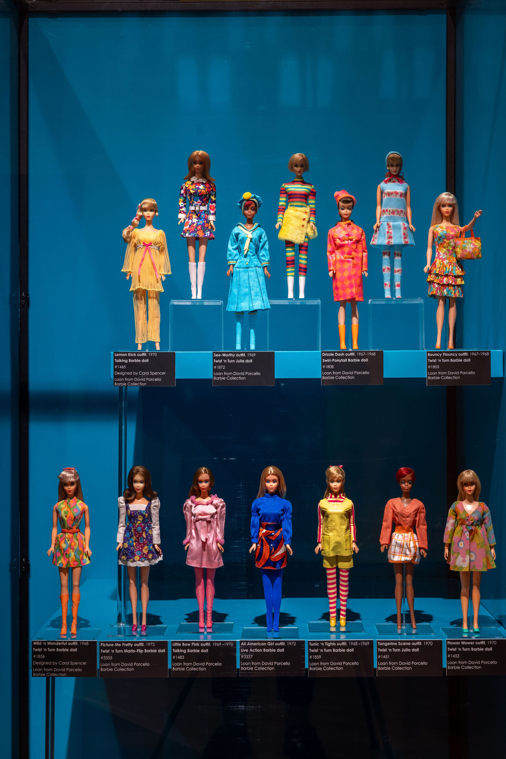 A case of Barbie dolls in a museum exhibit.