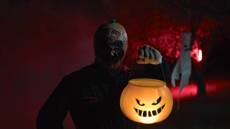 A ghoul holding a trick or treat bucket