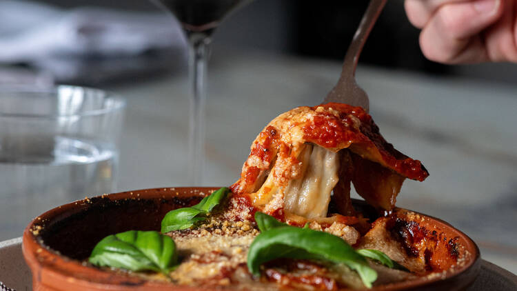 Eggplant parmagiana and a glass of red wine.