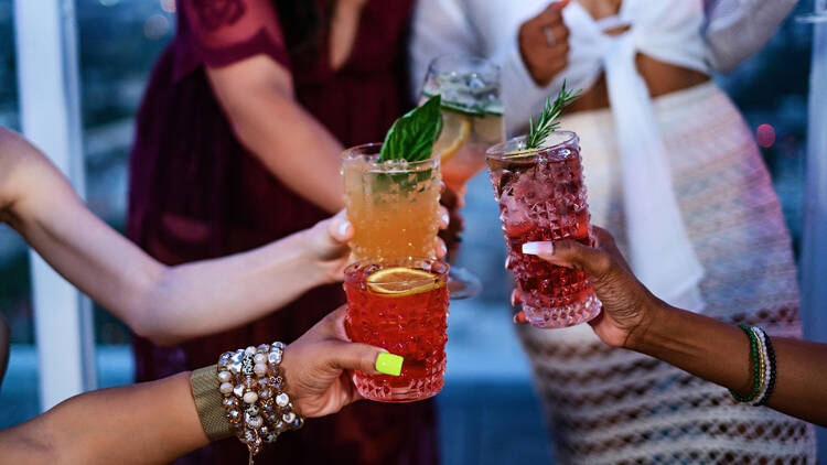 Friends cheers with cocktails on the rooftop of the Andaz West Hollywood.