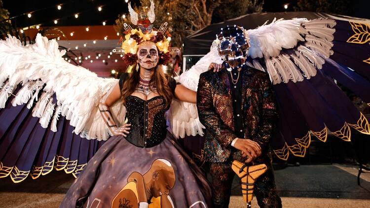 A man and woman in costume at the El Velorio Day of the Dead festival