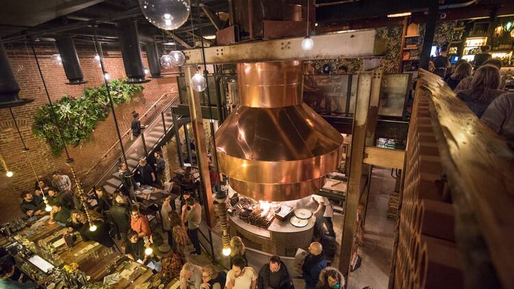 A view from the second floor overlooking the bar and massive oven at Maydan.