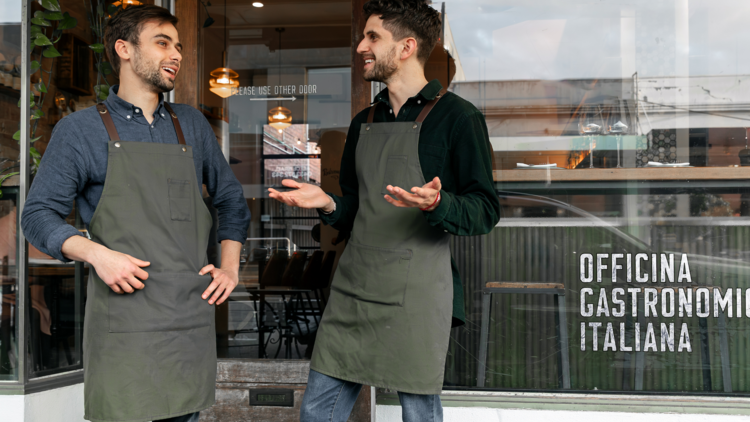 Waitstaff standing in front of Officina Gastronomica Italiana.