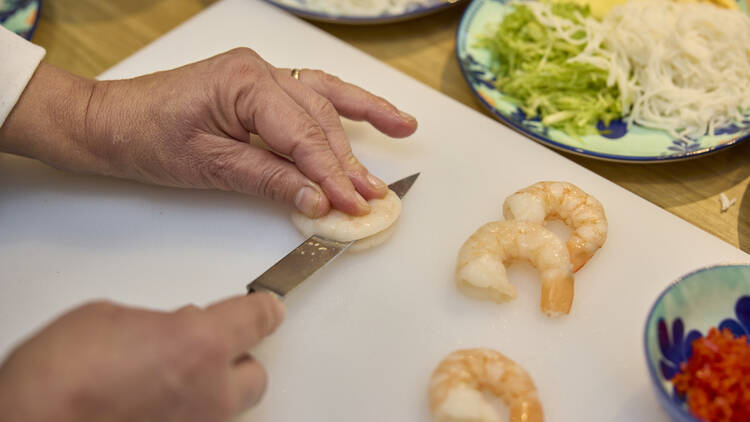 A person slicing prawns.