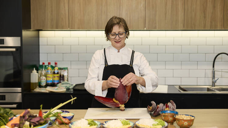 A chef preparing ingredients in a communal kitchen.