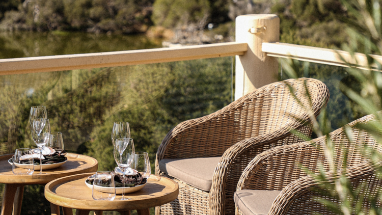 Pair of chairs and set tables on Moonah's balcony.