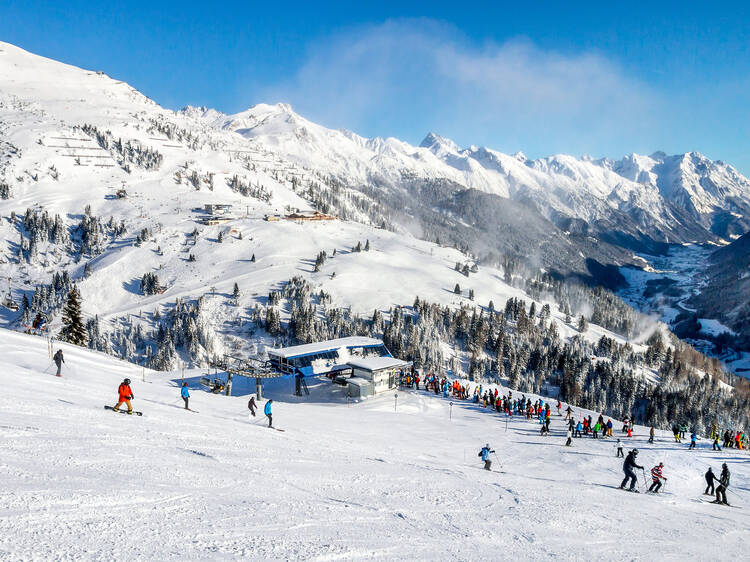 Skiers and snowboarders on the slopes of winter resort St. Anton, Austria.